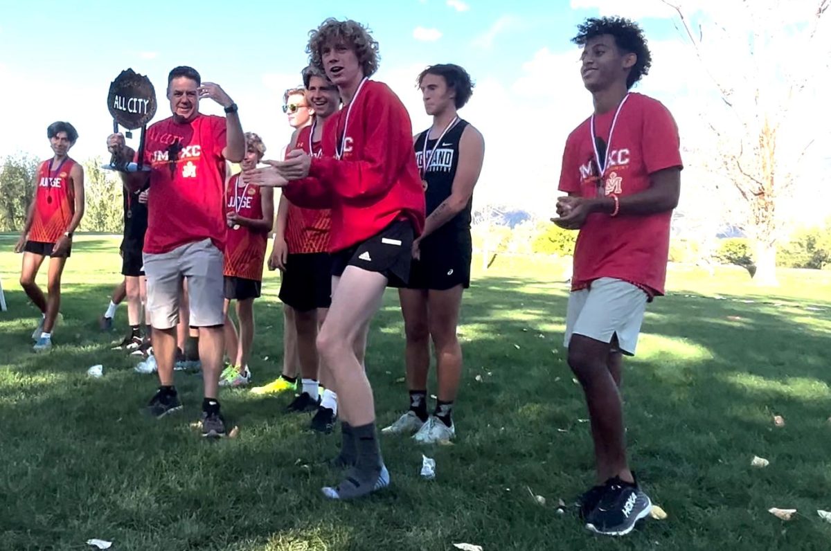 Coach Jason Heideman hoists the All-City trophy on Sept. 20. The boys and girls team edged out Highland by one point to claim the title.