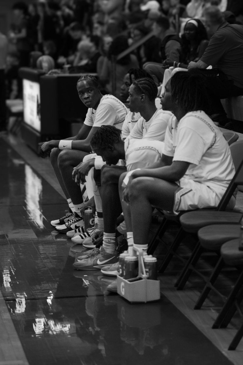 Varsity line up on the bench before game 