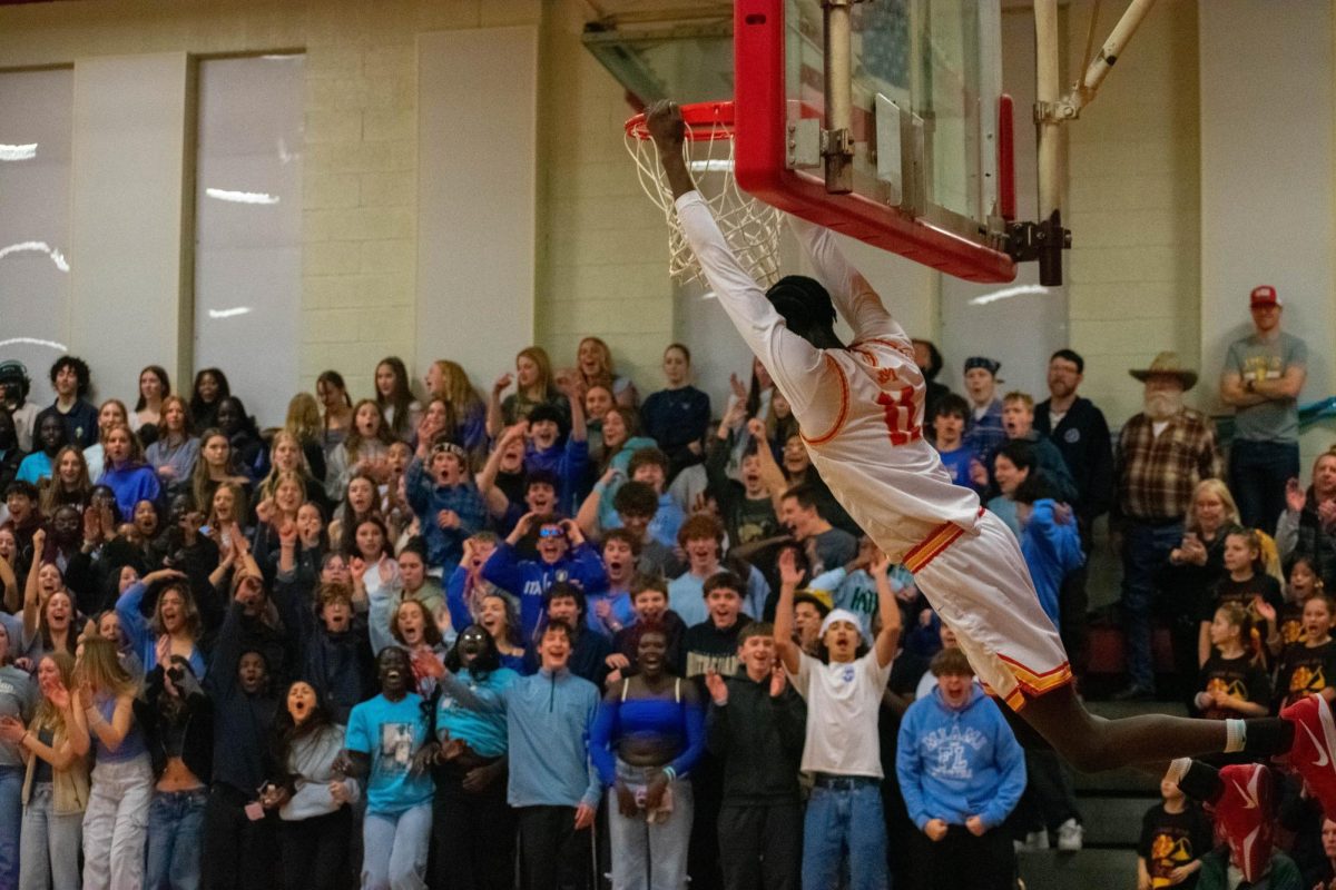 Aymen Ismael dunks against Summit Academy on January 31. The student body wore blue to honor Nuer Deng.