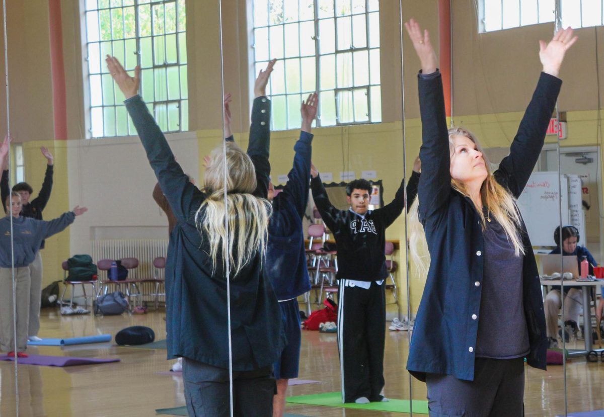 Ms. Beaumont teaches sun salutations in her 3rd period yoga class.