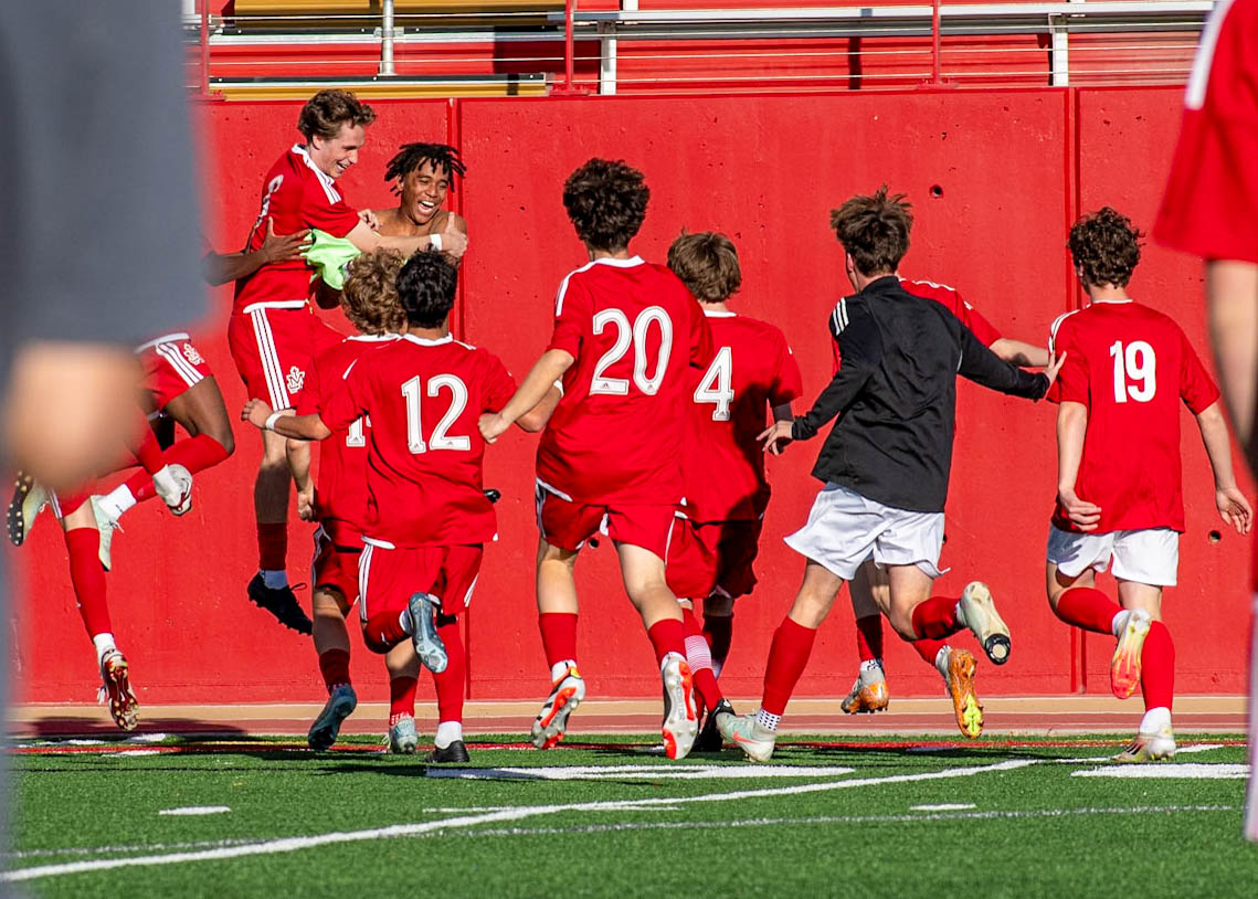 The soccer team runs to congratulate goalie Porter Smith after a shoot out win over Highland on March 17.